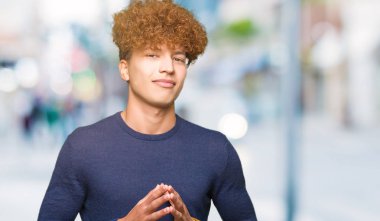 Yakışıklı delikanlı afro saç el ele tutusun ve parmakları ile rahat ve neşeli gülümseyen geçti. Başarı ve iyimser