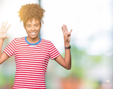 Güzel genç Afro-Amerikan kadın gösterilen ve parmakları ile işaret izole arka plan üzerinde numara 9 kendinden emin ve mutlu gülümseyerek süre.