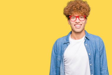 Afro saç gözlük ile mutlu ve güzel genç yakışıklı adamla yüzündeki gülümseme. Şanslı kişi.