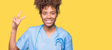 Genç Afro-Amerikan doktor kadın gösterilen ve parmakları ile işaret izole arka plan yüzünden kendinden emin ve mutlu gülümseyerek ise ikinci.