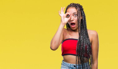 Genç örgülü saç Afrika kökenli Amerikalı pigmentasyon ile ok jest sürpriz yüz, göz parmaklarının arasından seyir şok yapıyor izole arka plan üzerinde Doğum işareti leke. İmansız ifade.