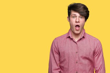 Genç yakışıklı iş adamı izole arka plan korkuyor ve şok sürpriz ifade, korku ve heyecan yüz üzerinden.
