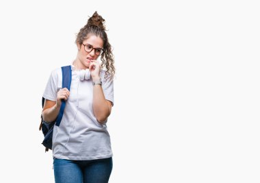 Stresli ve gergin elle çivi ısırma ağzına bakarak izole arka plan üzerinde sırt çantası ve kulaklıklar giyen genç esmer öğrenci kız. Anksiyete sorunu.