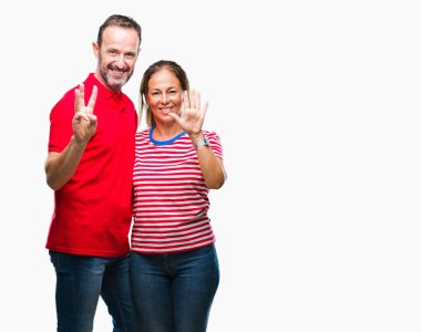 Orta yaş İspanyol çift aşık gösterilen ve parmakları ile işaret izole arka plan üzerinde kendinden emin ve mutlu gülümseyerek süre sekiz numara.