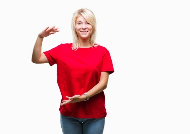 Büyük ve büyük boy işaret, ölçü birimi sembol gösteren ellerle eller izole arka plan üzerinde kırmızı t-shirt giyen genç güzel sarışın bir kadın. Kameraya bakarak gülümsüyordu. Ölçüm kavramı.