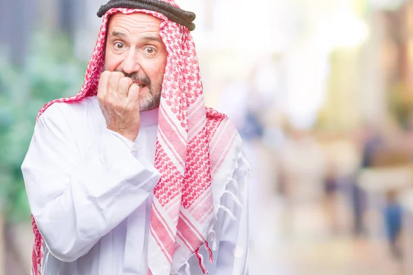 シニアのアラブ人は 不安や両手の爪を噛んで口の中で緊張を探して孤立の背景にクーフィーヤを着用します 不安の問題 — ストック写真