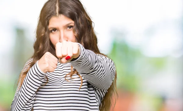 ストライプ セーター パンチ拳と戦うために 積極的なと怒って攻撃 脅威および暴力を身に着けている若い美しい女性 — ストック写真