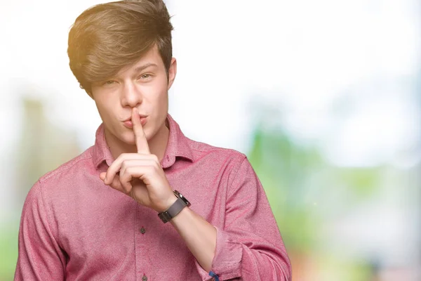 Young handsome business man over isolated background asking to be quiet with finger on lips. Silence and secret concept.