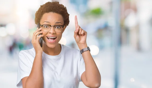 Mujer Afroamericana Joven Hablando Por Teléfono Sobre Fondo Aislado Sorprendida — Foto de Stock