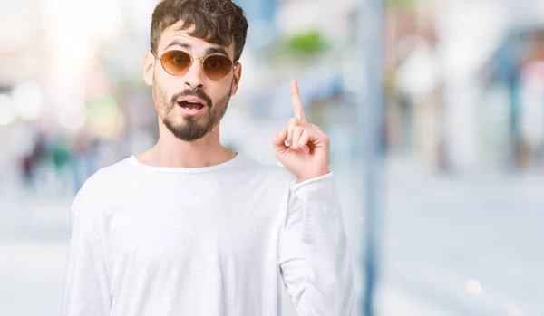 Homem Bonito Jovem Usando Óculos Sol Sobre Fundo Isolado Apontando — Fotografia de Stock