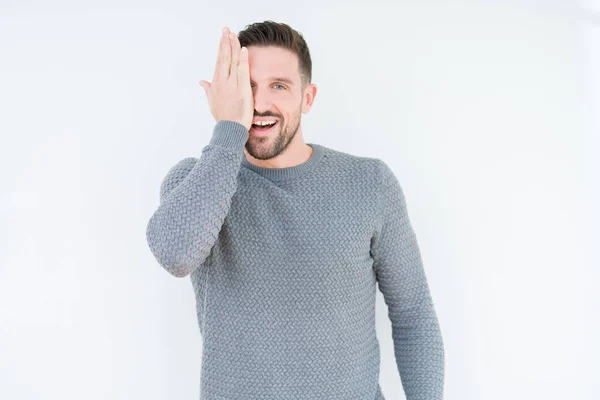 stock image Young handsome man wearing casual sweater over isolated background covering one eye with hand with confident smile on face and surprise emotion.