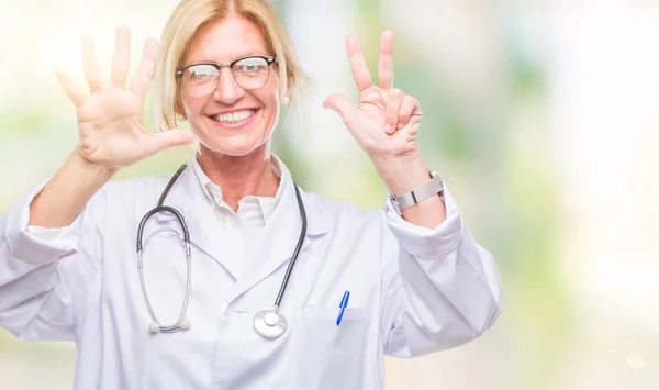 中年金发医生妇女超过孤立背景显示和指向与手指数字八同时微笑自信和快乐 — 图库照片