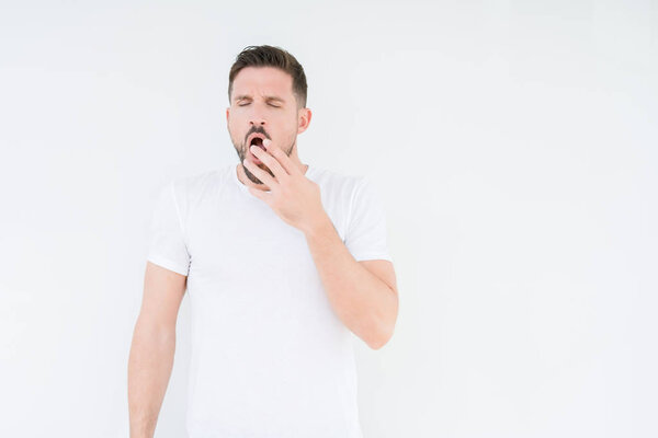 Young handsome man wearing casual white t-shirt over isolated background bored yawning tired covering mouth with hand. Restless and sleepiness.