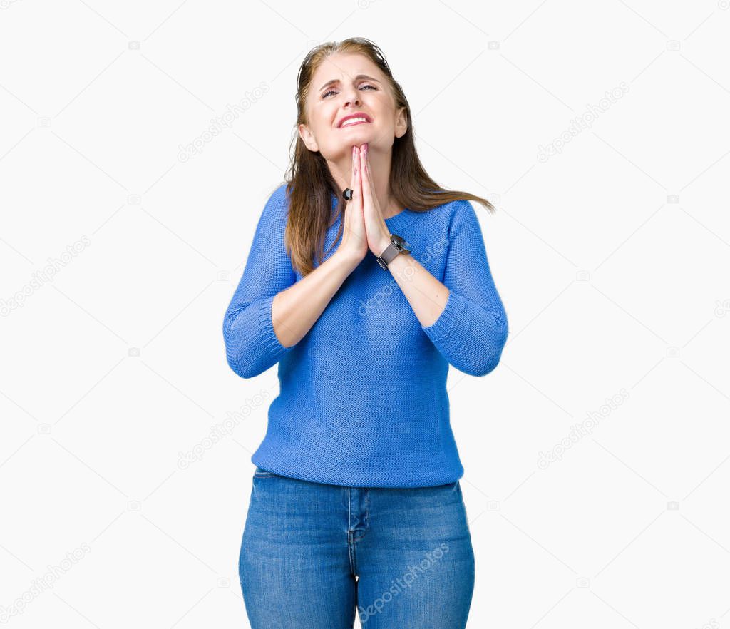 Beautiful middle age mature woman wearing winter sweater over isolated background begging and praying with hands together with hope expression on face very emotional and worried. Asking for forgiveness. Religion concept.