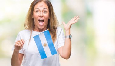 Arjantin bayrağı tutan orta yaş İspanyol kadın büyük gülümseme ile çığlık zaferini kutluyor ve ellerini kaldırdı arka plan çok mutlu ve heyecanlı, kazanan ifade izole