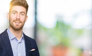 Hayret ve el ile sunulması ve parmak ile işaret ederken kameraya gülümseyen genç yakışıklı bussines adam.