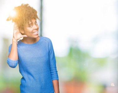 Güzel genç Afro-Amerikan kadın bir işitme söylenti ya da dedikodu için dinleme kulak üzerinde el ile gülümseyen izole arka plan yüzünden. Sağırlık kavramı.