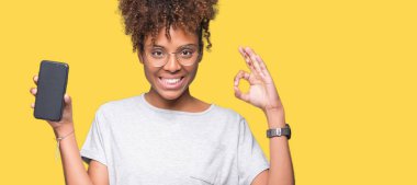 Genç Afro-Amerikan kadın gösteren smartphone ekran parmak, mükemmel sembolü ile ok işareti yapıyor izole arka plan üzerinde