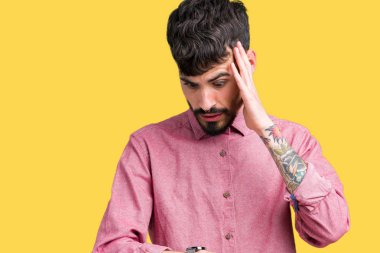 Yakışıklı delikanlı üzerinde pembe gömlek giymiş izole arka plan seyretmek zaman endişeli, geç korkuyor arıyorsunuz