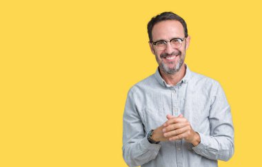 Arka plan eller üzerinde gözlük takan yakışıklı orta yaş zarif komuta sizde birlikte izole ve rahat ve neşeli gülümseyen parmak çarpı işareti. Başarı ve iyimser