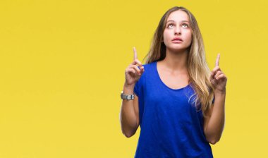 Genç güzel sarışın kadın izole arka plan üzerinden hayran ve yukarıya bakıp parmakları ile işaret şaşırttı ve silah kaldırdı.