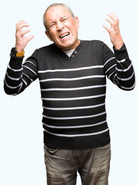 Üst düzey yakışıklı kış giyim kazak çılgın ve kızgın bağırarak ve agresif ifade ve silah kaldırdı bağırmaya çizgili. Hayal kırıklığı kavramı.