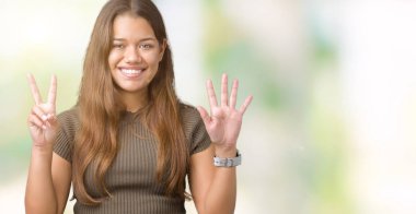 Genç güzel esmer kadın gösterilen ve parmakları ile işaret izole arka plan yüzünden kendinden emin ve mutlu gülümseyerek süre yedi numara.