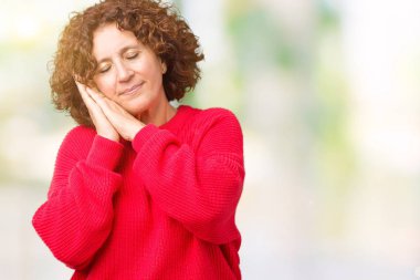 Güzel orta ager üst düzey kadın kırmızı kış kazak uyku yorgun hayal ve ellerle birlikte poz ile kapalı gözler gülümseyen izole arka plan üzerinde.