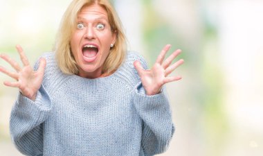 Üzerinde kış kazak giyen orta yaş sarışın kadın deli kutluyor arka plan izole ve başarı için kaldırdı kollarını açarak hayrete ve heyecanlı çığlık gözleri açık. Kazanan kavramı