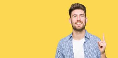 Casual Gömlek işaret parmağı ile başarılı fikir giyen genç yakışıklı sarışın adam. Çıktıktan ve mutlu. Bir numara.