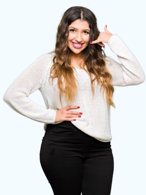 Gülümseyen beyaz kazak giyen genç güzel kadın el ve parmak telefonda konuşmak ile telefon jest yapıyor. Kavramları iletişim.