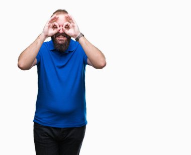 Dilini, parmaklarının arasından baktığını yapışmasını dürbün gibi ok jest yapıyor izole arka plan üzerinde mavi gömlek giymiş genç beyaz hipster adam. Deli ifade.