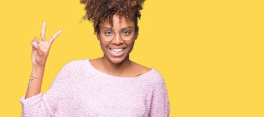 Güzel genç Afro-Amerikan kadın gözlük gösterilen ve parmakları ile işaret izole arka plan üzerinde kendinden emin ve mutlu gülümseyerek iken ikincisi.