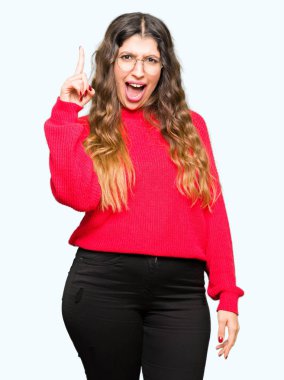 Kırmızı giyen genç güzel kadın başarılı fikirle işaret parmağı gözlük. Çıktıktan ve mutlu. Bir numara.