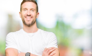 Yakışıklı adamın ile gülümseyen casual beyaz t-shirt mutlu yüz giydiğini silah kameraya bakarak geçti. Olumlu bir kişi.