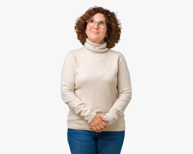 Boğazlı kazak ve gözlük görünümlü yan ve dik dik bakma uzağa düşünce gülümseyen izole arka plan üzerinde giyen güzel orta ager üst düzey kadın.