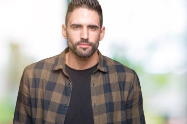 Yakışıklı delikanlı yüzünde ciddi bir ifade ile izole arka plan üzerinde. Basit ve doğal kameraya bakıyor.