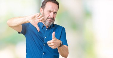 Yakışıklı orta yaş izole arka plan yapmaya başparmak yukarı ve aşağı, anlaşmazlık ve anlaşma ifade üzerinde zarif komuta sizde. Deli çatışma