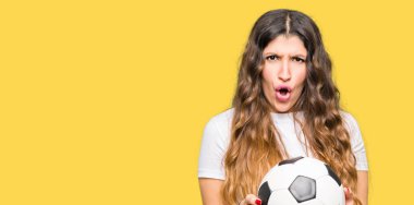 Futbol futbol topu bir sürpriz yüz, korkuyor ve heyecanlı korku ifadesi ile şok korkmuş tutan genç yetişkin kadın