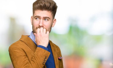 Genç yakışıklı iş adamı stresli ve gergin elle çivi ısırma ağzına bakıyor. Anksiyete sorunu.