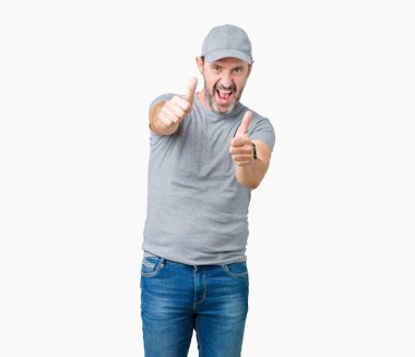 El ile pozitif jest yapıyor onaylama izole arka plan üzerinde spor şapkası yakışıklı orta yaş ağarmış komuta sizde başparmak gülümseyen ve başarı için mutlu. Kamera, kazanan jest arıyorsunuz.