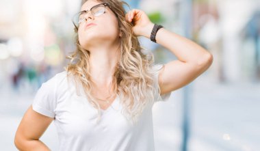 Güzel genç sarışın kadın üzerinde gözlük takan arka plan geri uzanan izole, yorgun ve rahat, uykulu ve erken sabah esneme