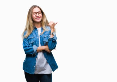 Seyir ve başparmak yanında yukarıyı mutlu yüz ile gülümseyen izole arka plan üzerinde gözlük takan genç güzel sarışın kadın.