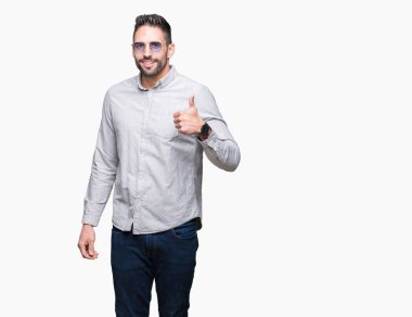 Genç yakışıklı adam hareketi el ile mutlu yaşasın yapıyor izole arka plan üzerinde güneş gözlüğü takıyor. Kameraya bakarak başarı gösteren ile ifade onaylama.