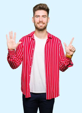 Gösterilen ve parmakları ile işaret kırmızı gömlek giymiş genç yakışıklı adam kendinden emin ve mutlu gülümseyerek süre yedi numara.