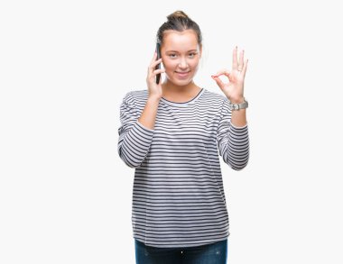 Genç güzel beyaz kadın parmakları, mükemmel sembolü olan ok işareti yapıyor izole arka plan üzerinde Smartphone'da söz