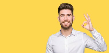 El ve parmak ile ok işareti yapıyor olumlu gülümseyen genç yakışıklı iş adamı. Başarılı ifade.