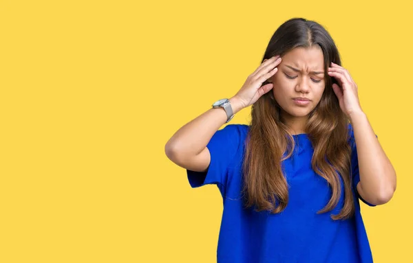 若い美しいブルネット女性の騒々しい音楽のノイズの腹が立つ式の指を使って耳をカバー分離の背景に青い シャツを着てします 聴覚障害者の概念 — ストック写真