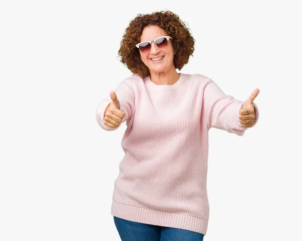 손으로 긍정적인 제스처를 분홍색 스웨터와 선글라스를 성공을 미소를 카메라 우승자 — 스톡 사진