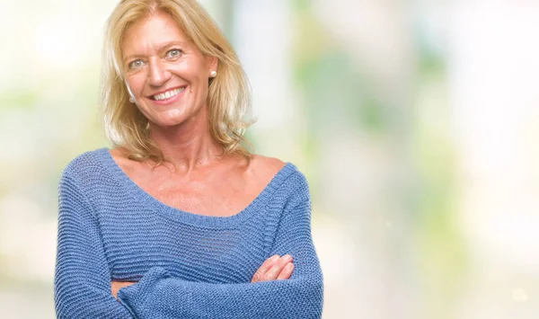 Middle age blonde woman wearing winter sweater over isolated background happy face smiling with crossed arms looking at the camera. Positive person.